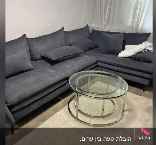 ספה אפורה עם שולחן זכוכית עגול על שטיח בהיר